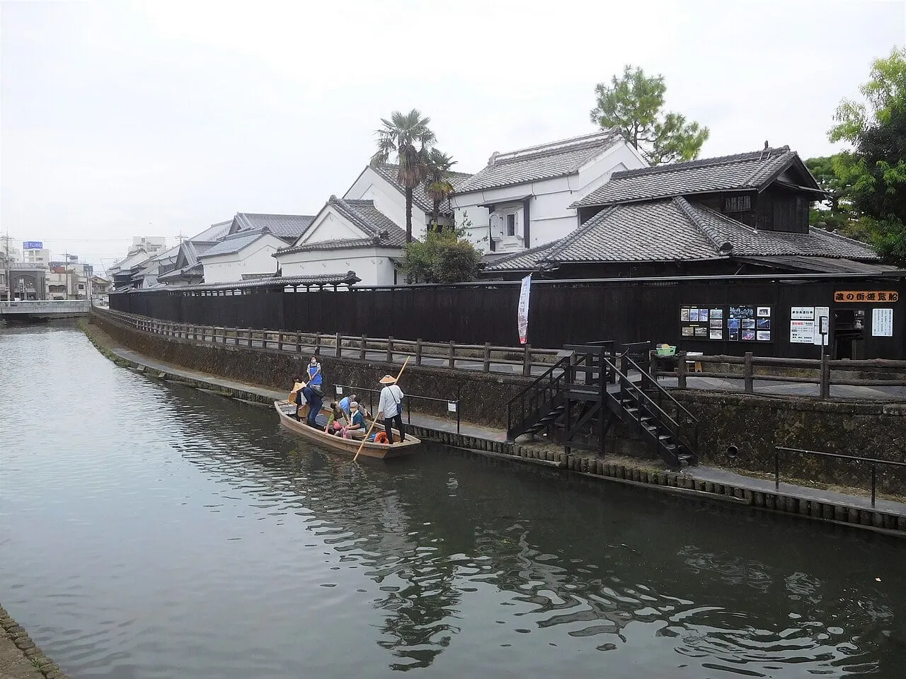 巴波川を進む蔵の街遊覧船。川沿いに黒塀と白壁の蔵が続く。